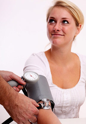 Woman having her blood pressure checked by a doctor who is not shown